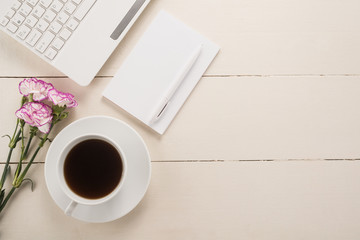 Office table with cup of coffee and flowers 