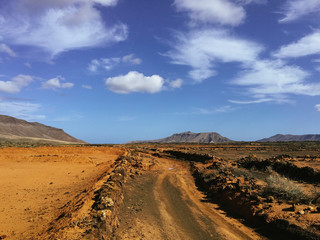 Beautiful view overlooking rusty red desert, distant mountains in Fuerteventura island, Canaries, Spain