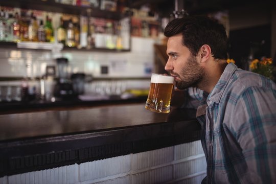 Man drinking beer at counter