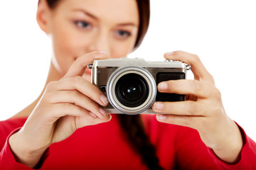Pretty woman taking a photo using classic slr camera