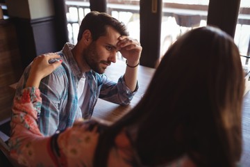 Woman consoling man at counter