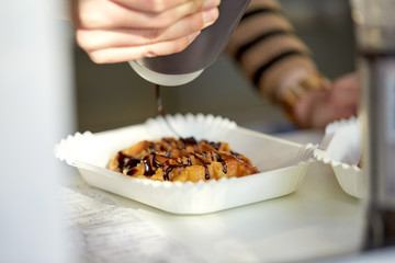 close up of cook adding syrup to waffle