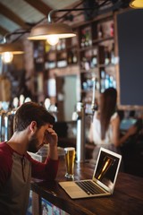 Upset man using laptop