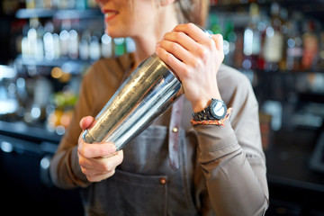 close up of bartender with cocktail shaker at bar