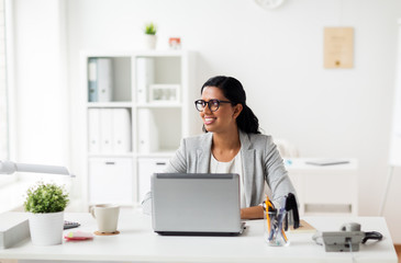 Obraz na płótnie Canvas happy smiling businesswoman with laptop at office