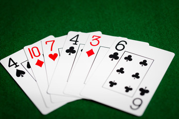 poker hand of playing cards on green casino cloth