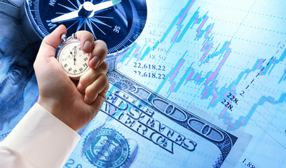 Candlestick chart, compass, dollars and stopwatch in male hand