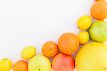 Tasty frame made of fresh lemon, orange, mandarin, grapefruit, sweetie and pomelo fruit on white background. Flat lay, top view.