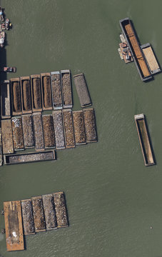 Aerial view of rocks and ores on barges in sea