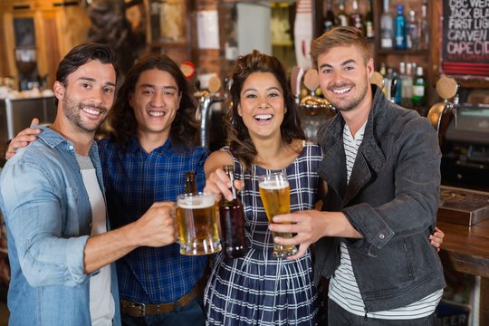 Portrait Of Friends Tossing Beer Glasses And Bottles In Pub