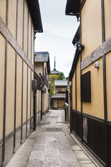 Traditional Street in Kyoto, Japan with distant temple spire.