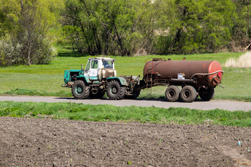 Old tractor driving on the rural road