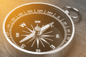 Old vintage retro compass on wooden background