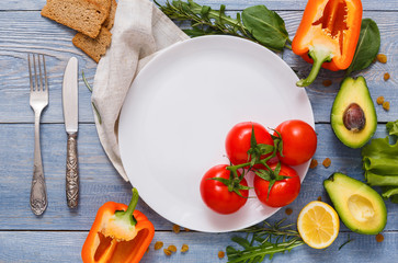 Border of fresh vegetables on blue wood background with copy space