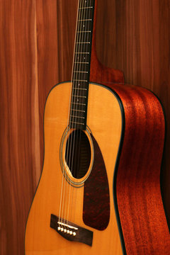 Acoustic guitar and on a wood background.