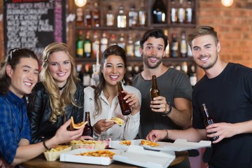 Portrait of friends having pizza with beer