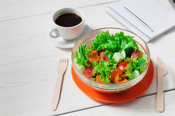 Healthy eating in office, vegetable salad bowl and coffee