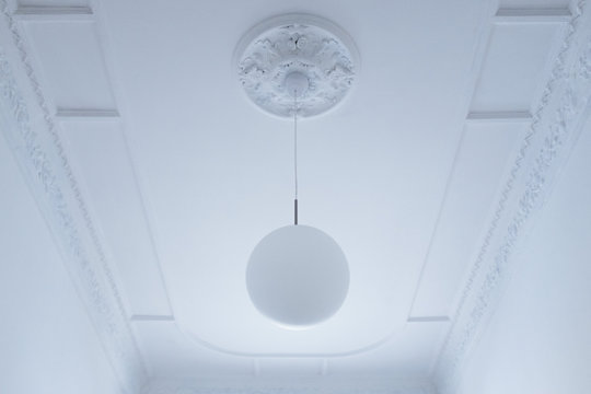 Low angle view of pendant light hanging from white ceiling at home