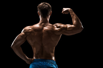 Fototapeta premium Strong Athletic Man Fitness Model posing back muscles, triceps over black background