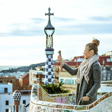 tourist woman at Guell Park taking photo with digital camera