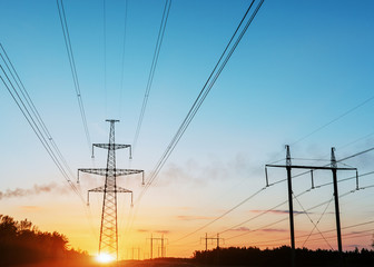 high-voltage power lines at sunset. electricity distribution station.