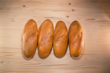 Fresh bread on the wooden table background. Bakery concept. bunch of loafs lies in line.