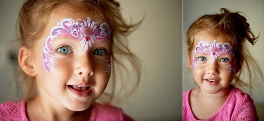 Pretty exciting blue-eyed girl of 2 years with a pink face painting