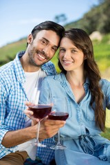 Portrait of young couple holding red wine glasses