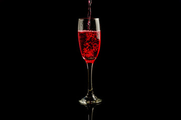 bottle and glass with red wine on black background