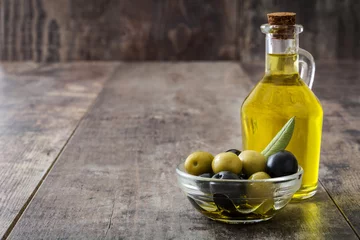 Gordijnen Virgin olive oil in a crystal bottle on wooden background   © chandlervid85