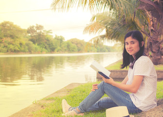 young beautiful woman relaxing in park nearby lake