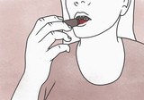 Cropped image of woman applying red lipstick against colored background