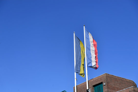 Schleswig Holstiner und Eckernförder Fahne wehen vor blauem Himmel