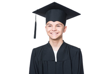 Portrait of a graduate teen boy student in a black graduation gown with hat - isolated on white background. Child back to school and educational concept.