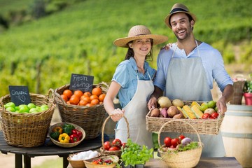 Smiling couple standing by fresh fruits and vegetables
