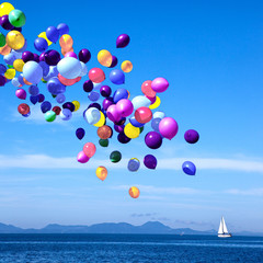 Colorful balloons drifting over the calm blue sea.