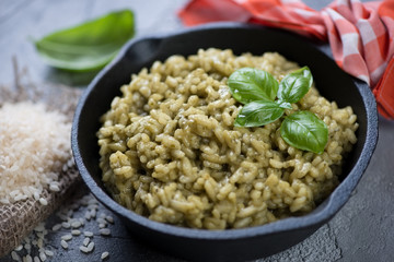 Closeup of a frying pan with spinach risotto, selective focus, horizontal shot