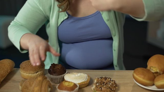 Corpulent young woman eating pastry  greedily, overeating unhealthy fatty food