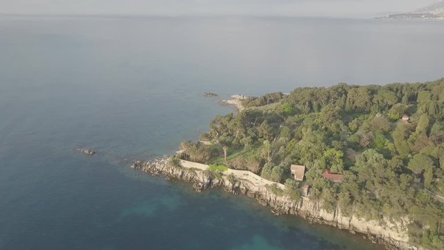 Flight over the mediterranean coastline on the border Italy France. Capo Mortola, Grimaldi (Ventimiglia), Italy, Europe. Aerial panoramic view 4K, UHD native log movie.