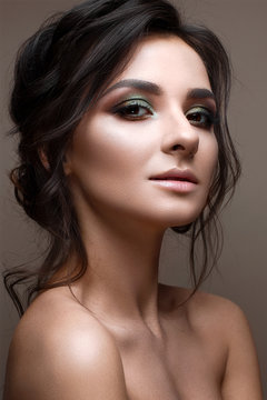 A young girl with bright creative makeup and evening hairstyle. Beautiful model with perfect skin. Beauty of the face. Photo is taken in the studio.