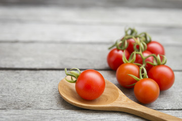 Closeup red cherry tomato with space on wood background