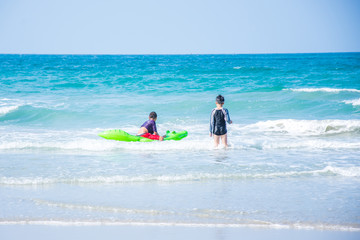 Fototapeta na wymiar two children on the beach and sky blue