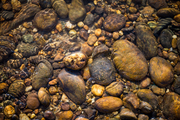 Natural color stone under clear river water, nature background