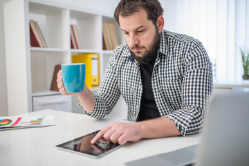 Handsome man working on tablet in office