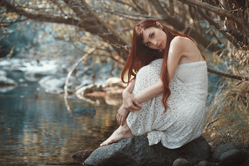 Romantic woman close to a stream
