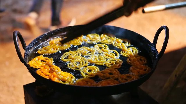 Man cooking Indian street sweets Jalebi. A sweet Indian Food in Goa.