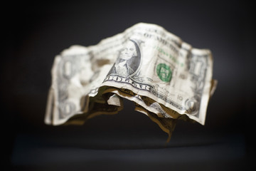 Close-up of crumpled old American one dollar bills levitating against black background