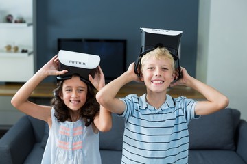 Portrait of siblings holding virtual reality headset