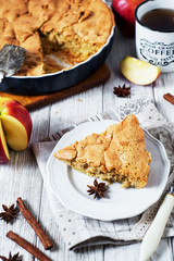 Homemade cake, apple pie with apples from a biscuit dough with cinnamon and black tea on a white rustic wooden background 
