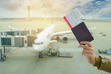 hand hold ticket and passport on airport background